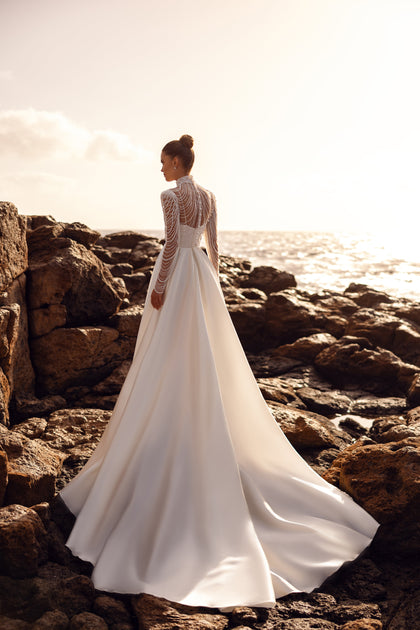 Brautbluse Alya mit langen, perlenbesetzten Ärmeln und elegantem Schleppeffekt für einen königlichen Hochzeitslook.