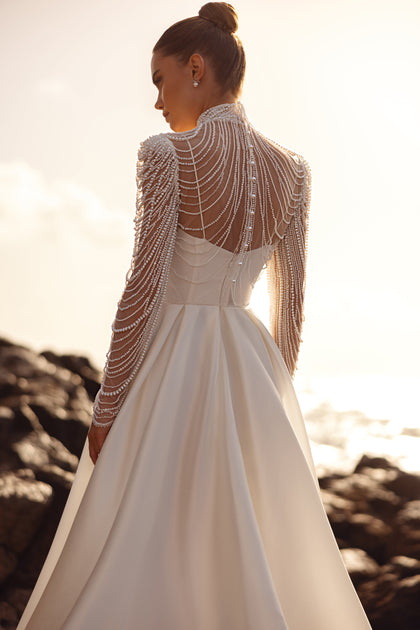 Brautbluse Alya mit langen Ärmeln und perlenbesetztem Rückendesign für einen atemberaubend eleganten Hochzeitslook.
