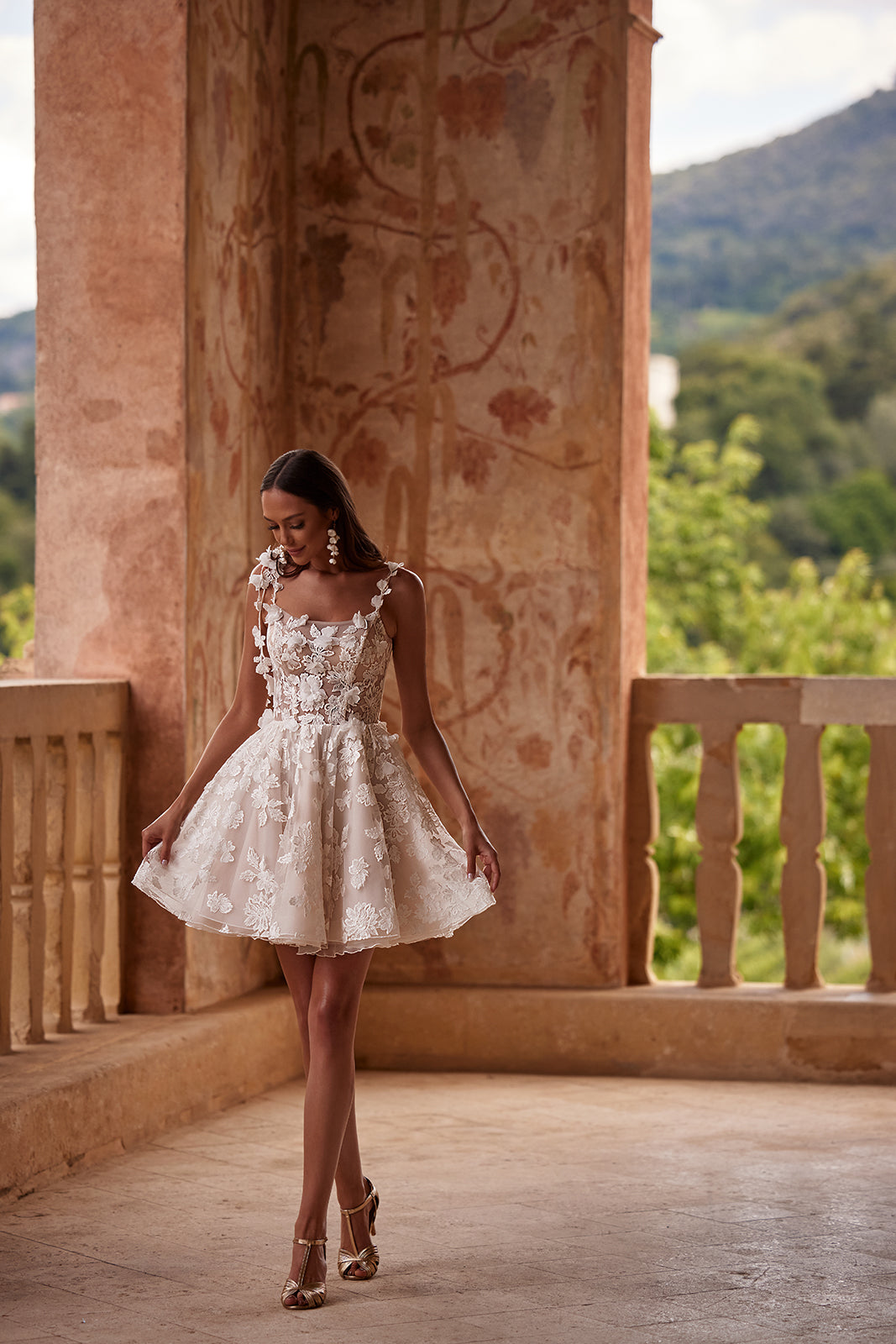 Kurzes Brautkleid Amanda in Skater-Silhouette, ganze Figur mit Blütengirlande an der Schulter