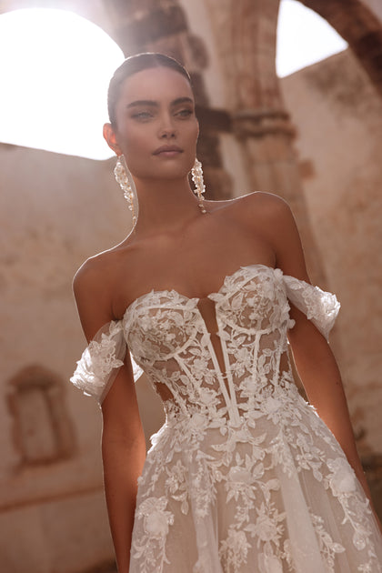 Eine Nahaufnahme des Korsetts von Ariella zeigt filigrane florale Spitzenapplikationen, die das romantische Design des Kleides betonen.