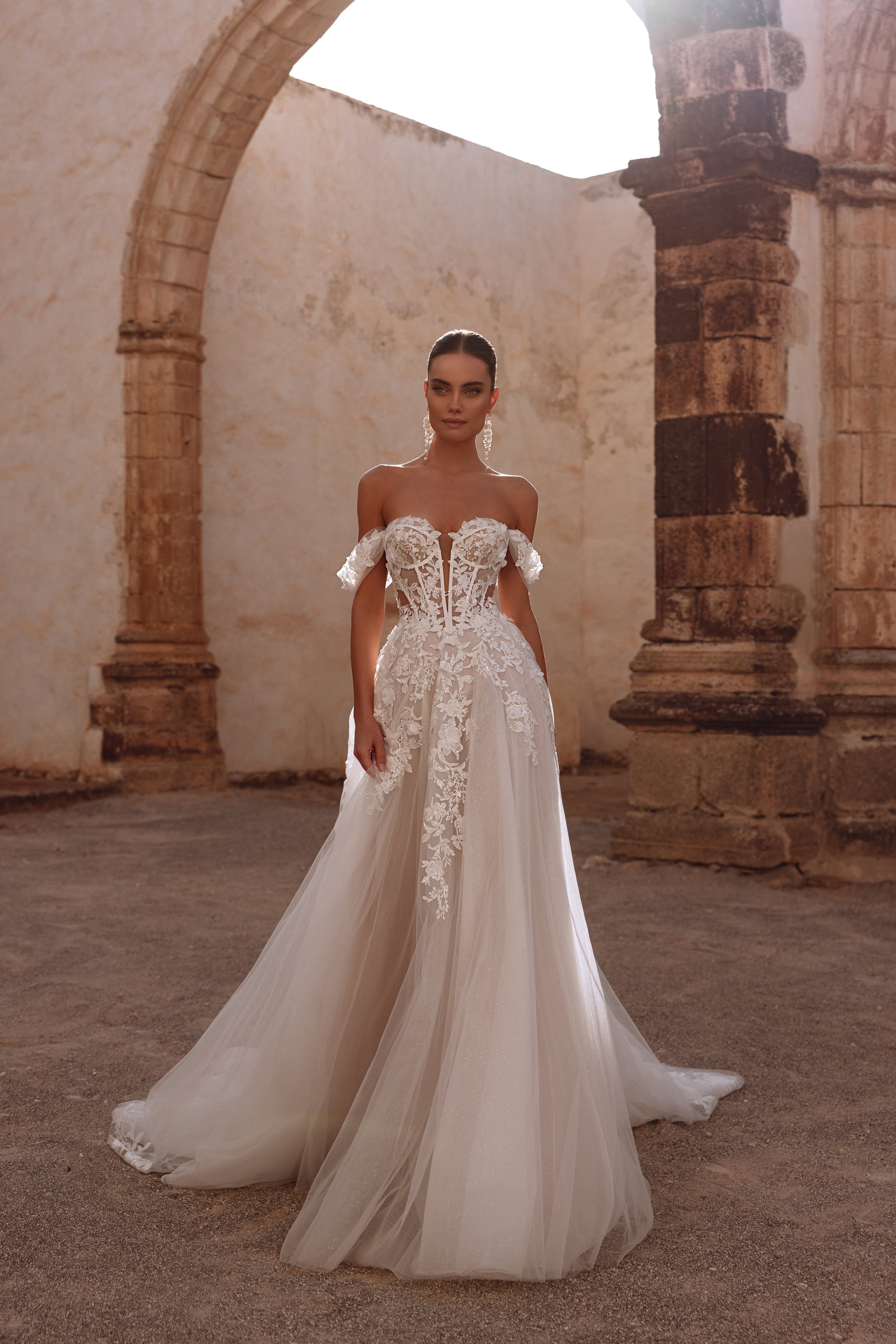 Ariella bridal dress has a corset with visible boning and intricate floral lace appliqués, offering a delicate, ethereal elegance.