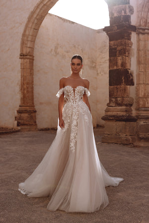 Das Brautkleid Ariella von DAMA Couture verfügt über ein Korsett mit sichtbaren Stäbchen und reich bestickte, florale Spitzenapplikationen – für einen ätherischen, eleganten Look.