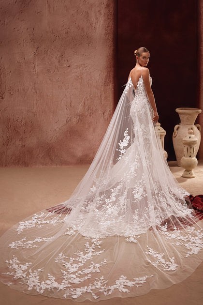Die Aspasia Brautcape aus feinem Tüll mit 3D-Blumenapplikationen verleiht dem Hochzeitskleid einen romantischen und luxuriösen Look.