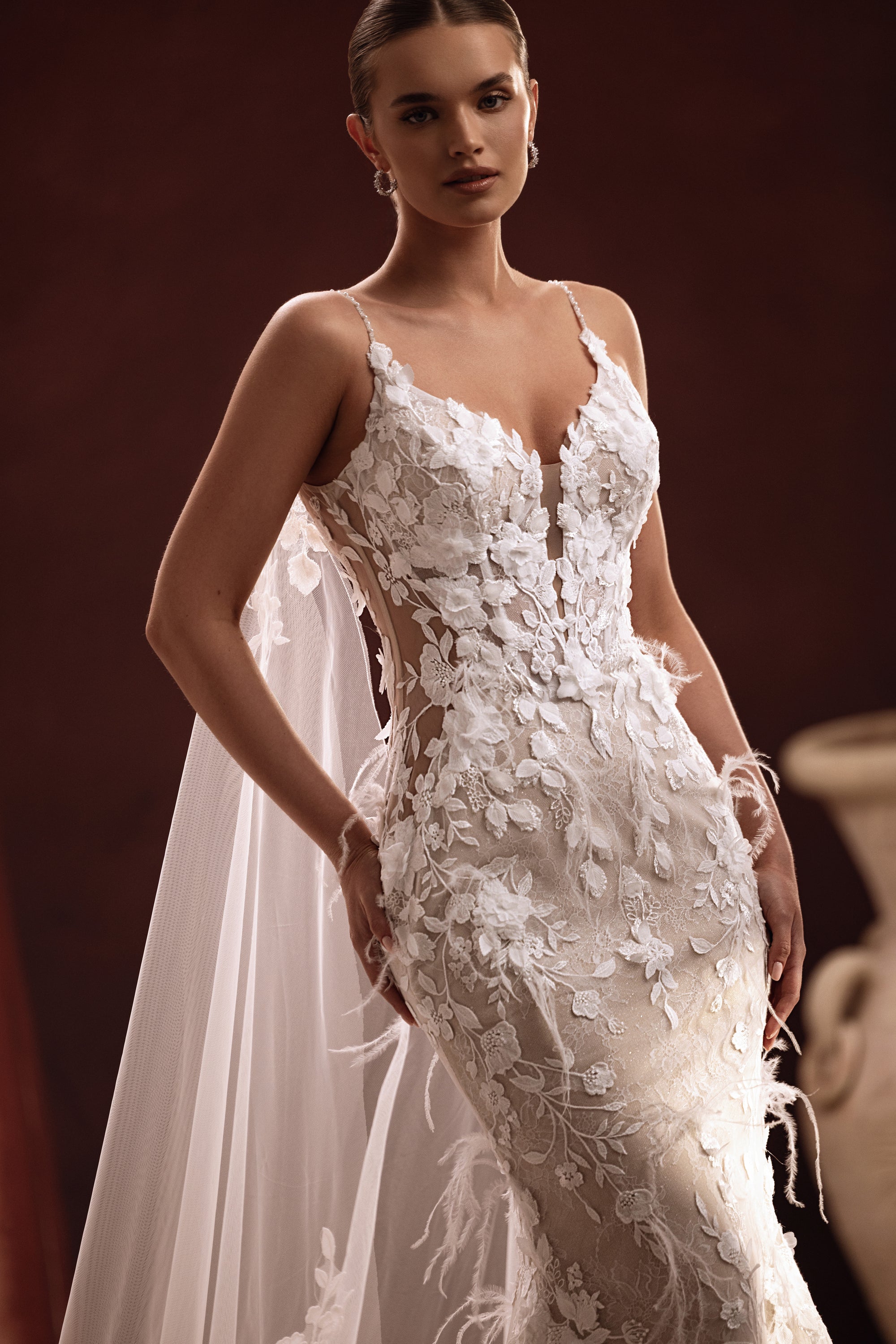 Aspasia long bridal cape with lace embroidery on the train creates a luxurious and elegant wedding day look.
