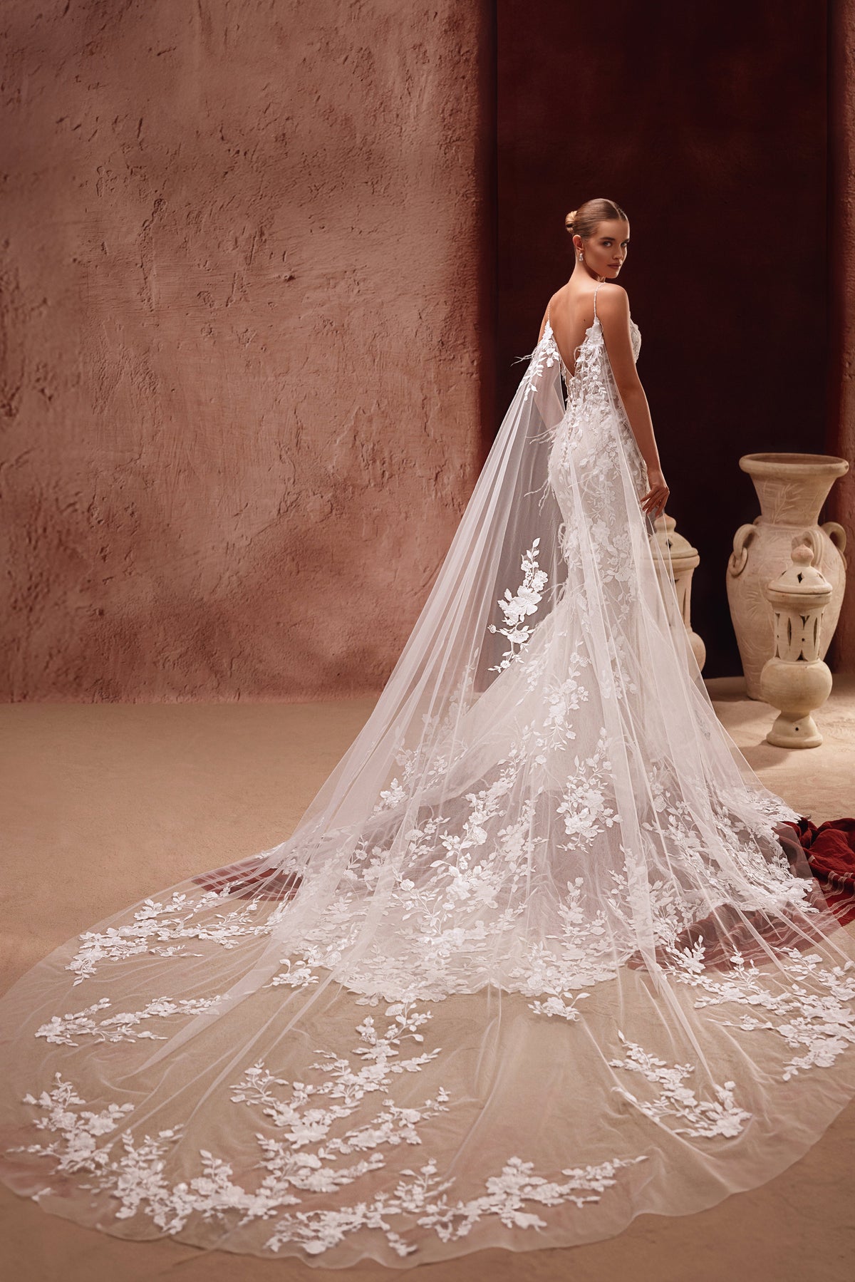 Brautcape Aspasia aus Tüll mit 3D-Blütenapplikationen, Detailaufnahme über dem Brautkleid