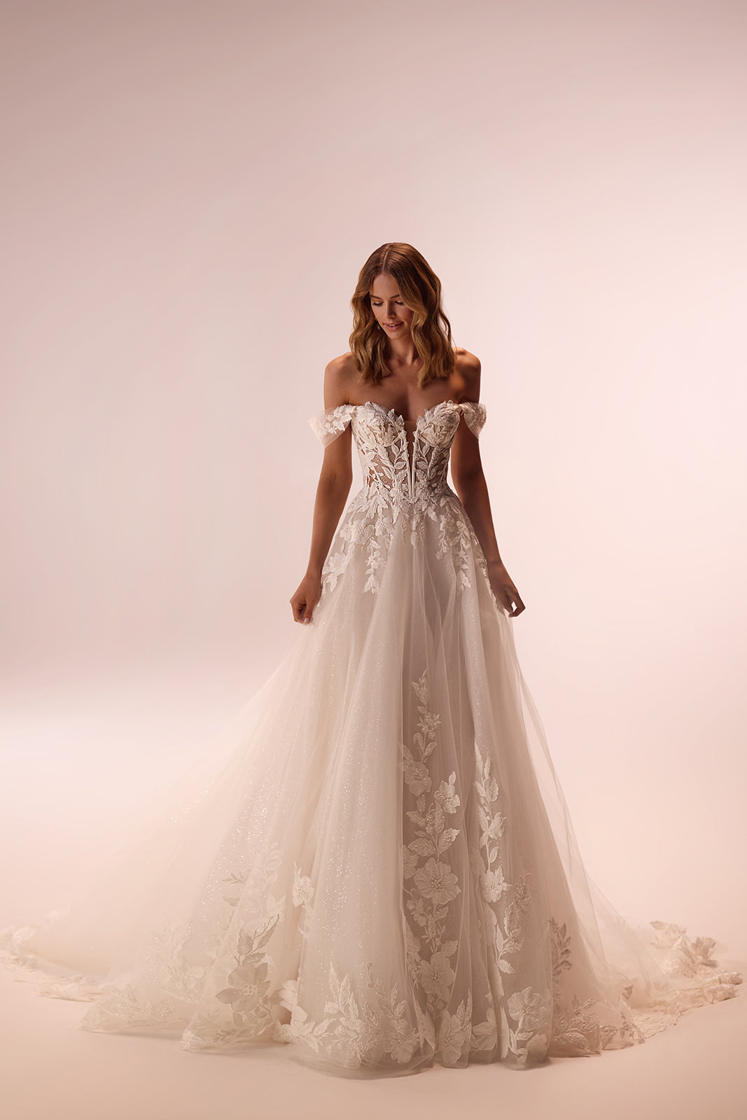 Brautkleid Aurora im Studio, ganze A-Linien-Silhouette mit Spitzenapplikationen auf Glitzertüll