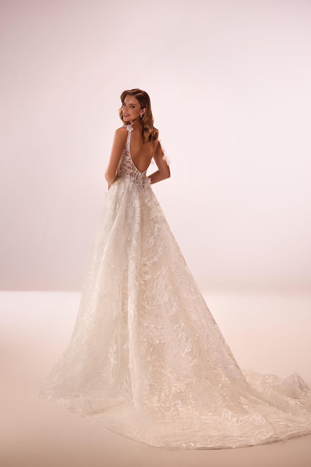 Brautkleid Celia von hinten, offener Rückenausschnitt und lange Schleppe aus glitzernder Spitze