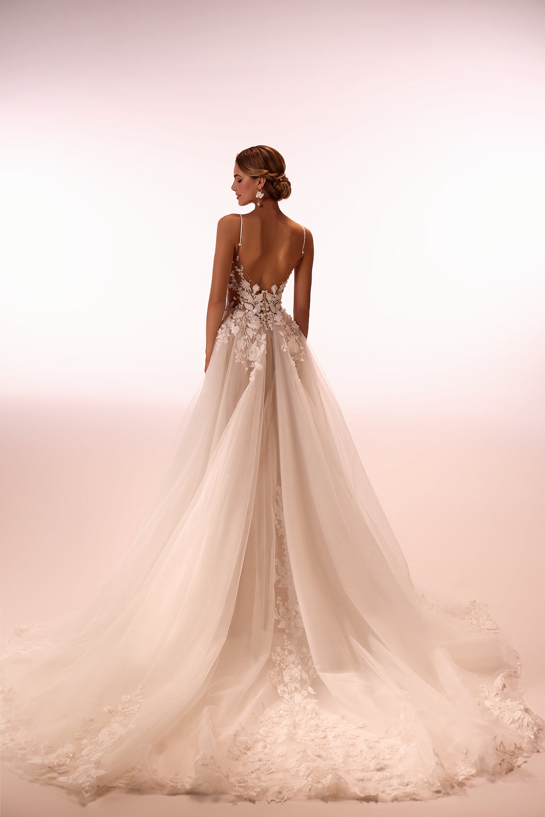 Brautkleid Claire im Studio von hinten, tiefer Rückenausschnitt und weit ausgebreitete Schleppe