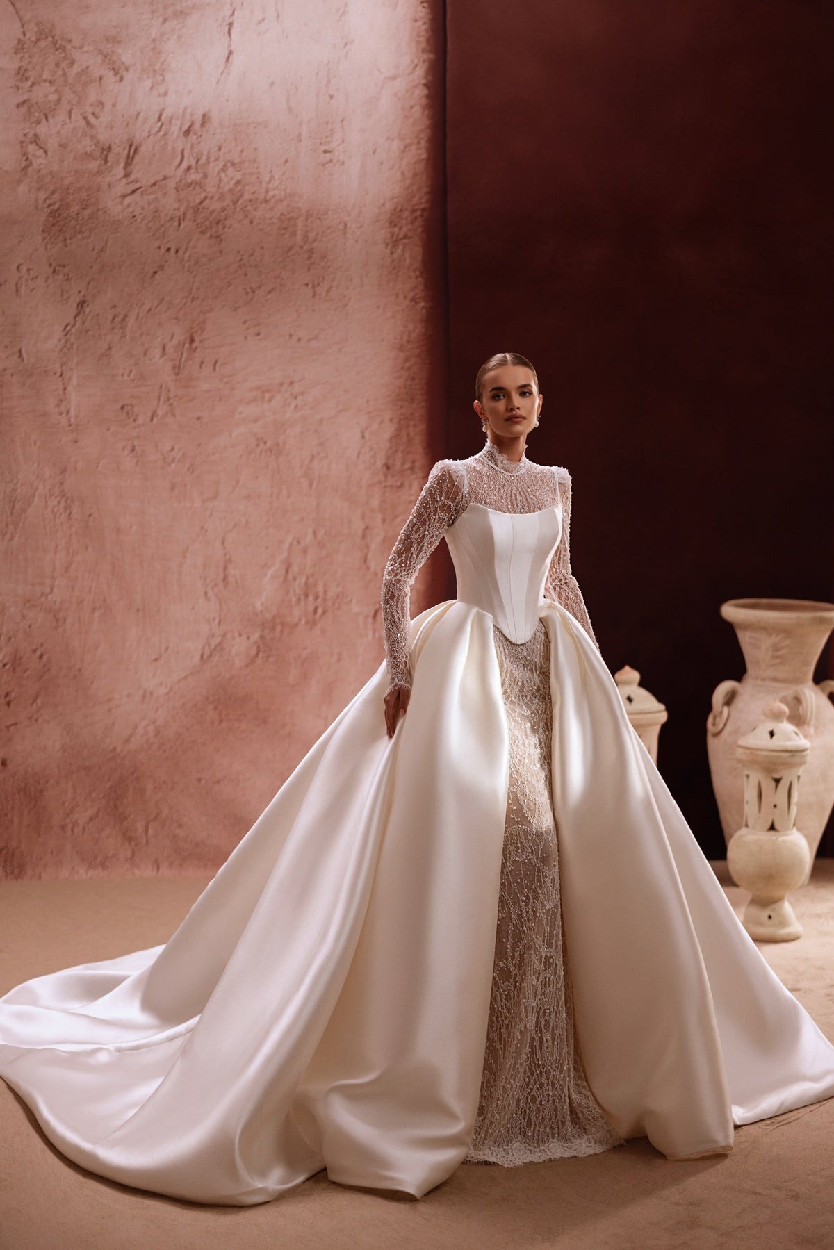 The Henriette overskirt features shimmering lace details and satin train, perfect for a modern luxury bridal gown.