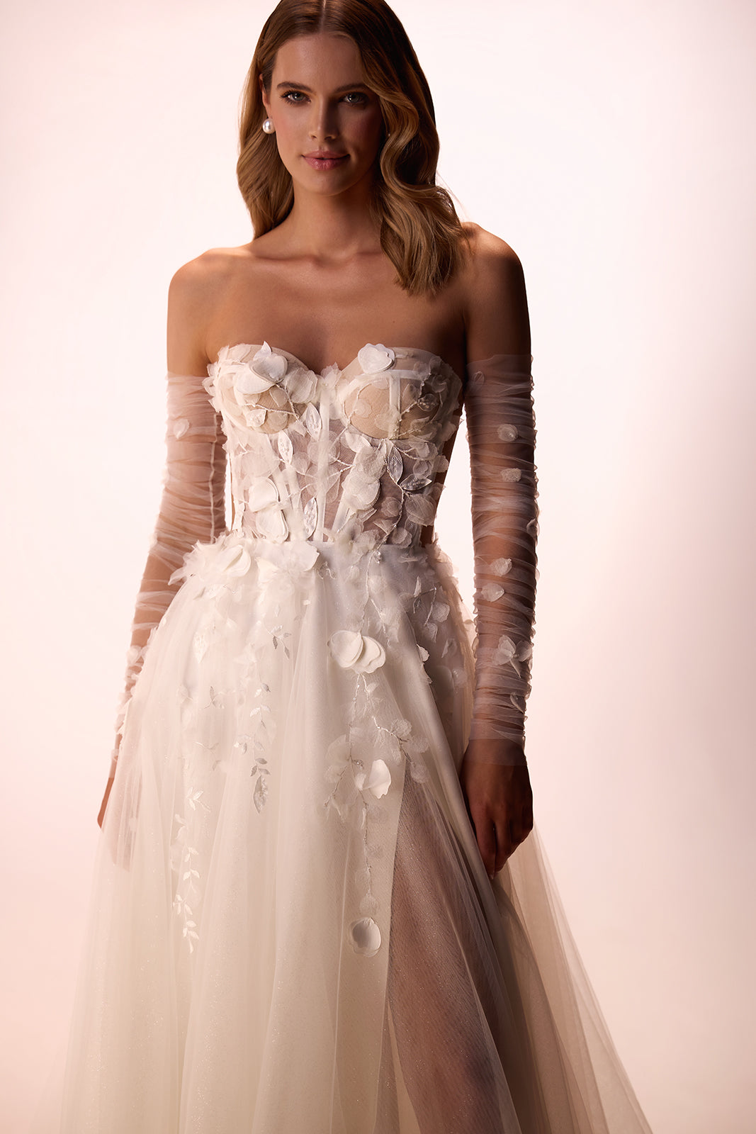 Brautkleid Ilimaris im Studio, Blumenapplikationen auf der Corsage und Tüllärmel