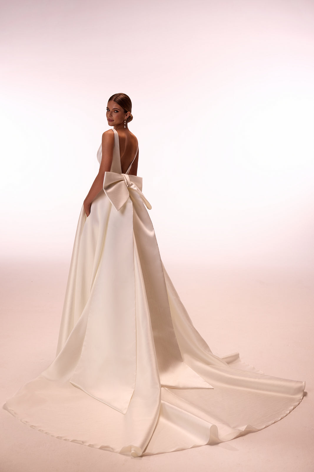 Brautkleid Margo im Studio von hinten, Satinschleife und ausgebreitete Schleppe