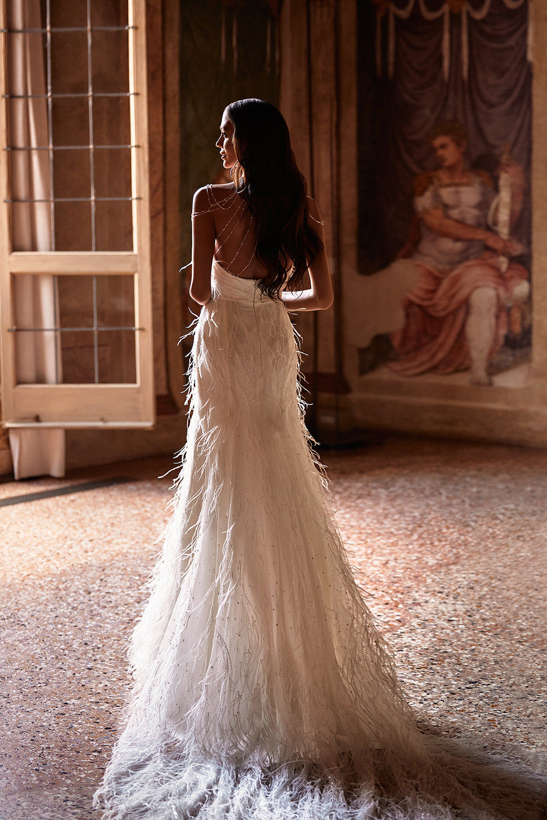 Brautkleid Odette von hinten, offener Rücken mit Perlenketten und Federrock mit Schleppe