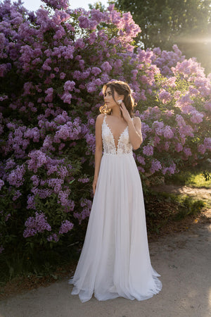 Brautkleid Rosaline in A-Linie mit leichtem Tüllrock, ganze Silhouette vor blühendem Flieder