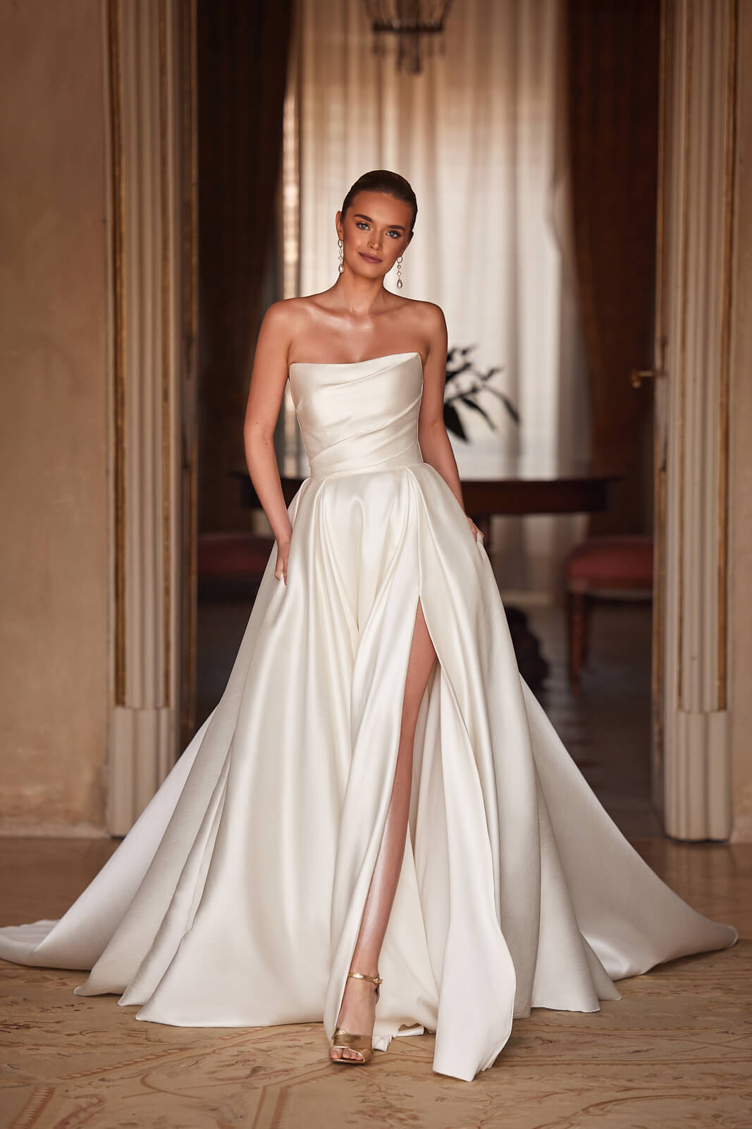 Brautkleid Madelaine in A-Linie, ganze Silhouette von vorn mit hohem Seitenschlitz im Satinrock