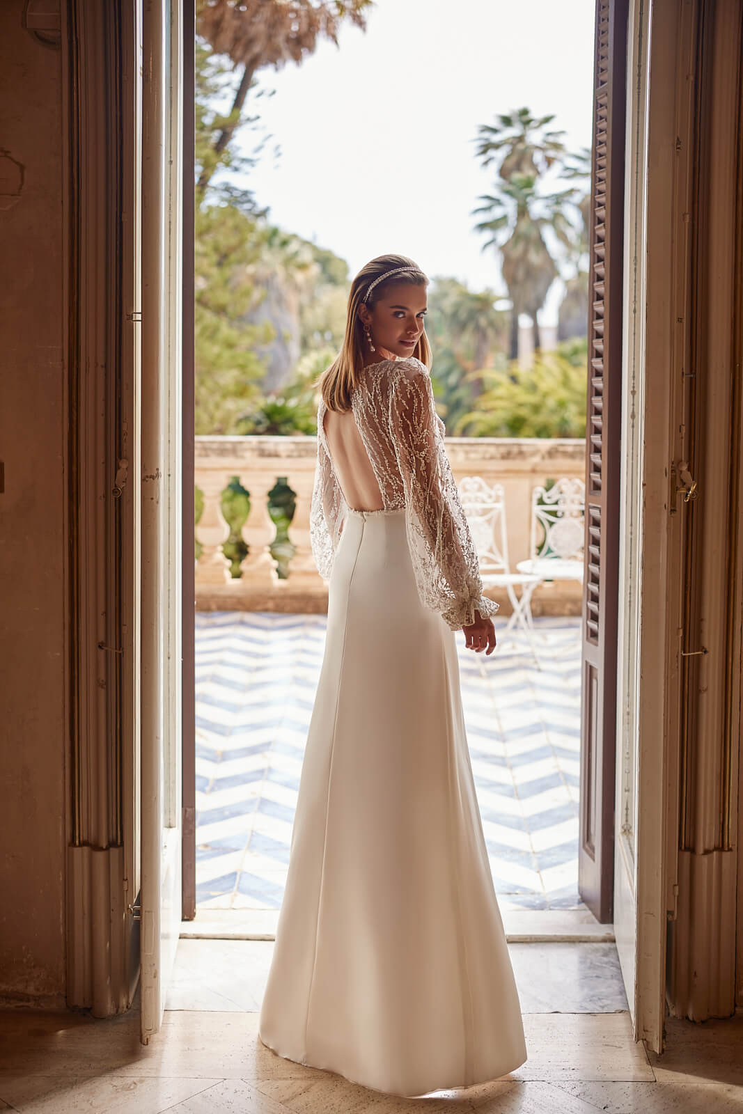 Brautkleid Paula von hinten, durchbrochene Spitzenärmel und schmaler langer Rock, ganze Figur