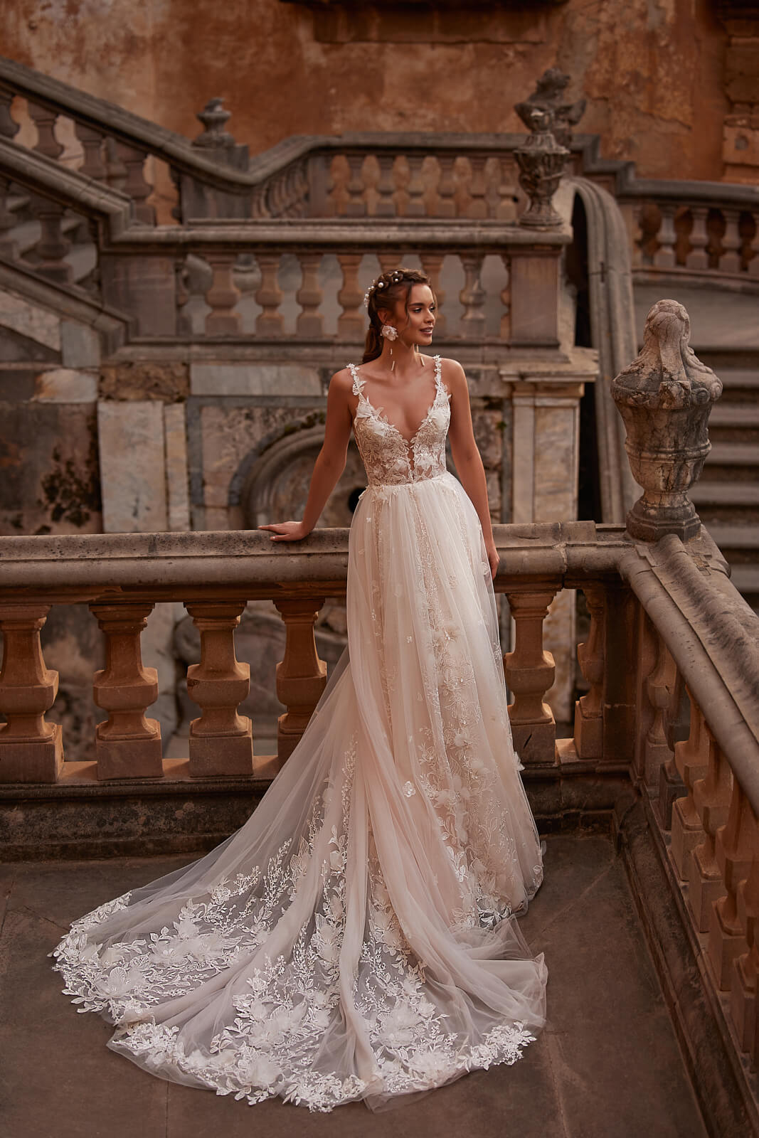Brautkleid Sandi in ganzer Figur auf der Steintreppe, A-Linie aus Tüll mit langer Schleppe