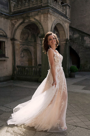 Brautkleid Gilly seitlich im Hof, ausgebreitete Tüllschleppe und Blumenspitze