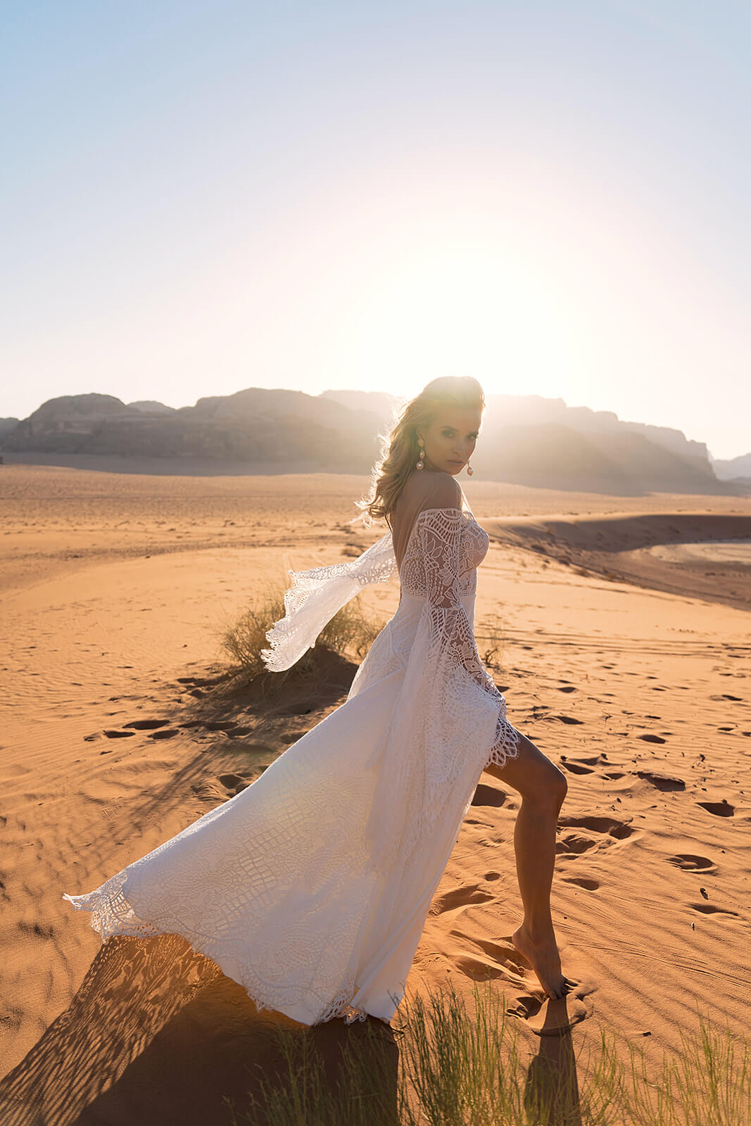 Brautkleid Lea in A-Linie aus Spitze, wehende Ärmel und Rock, ganze Silhouette in der Wüste