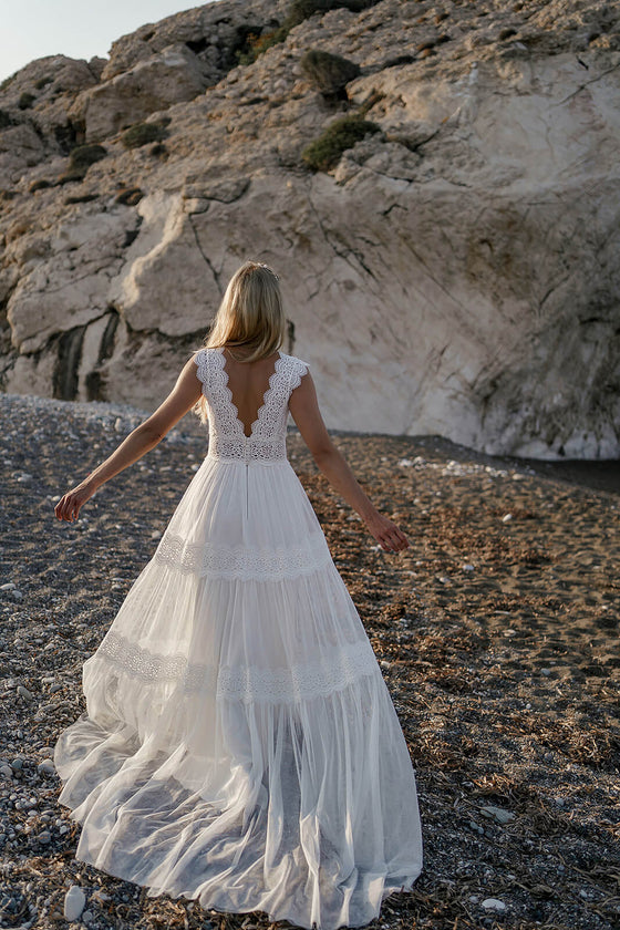 Brautkleid Lidia in Bewegung am Kiesstrand, der leichte Rock schwingt zur Seite