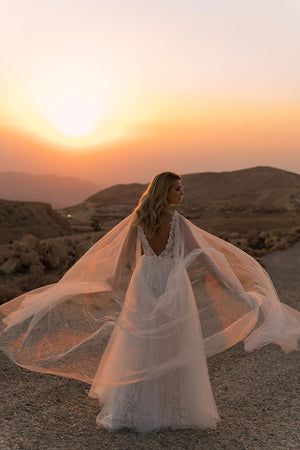 Brautkleid Linda von hinten, weites Tüllcape im Wind über der Wüstenlandschaft