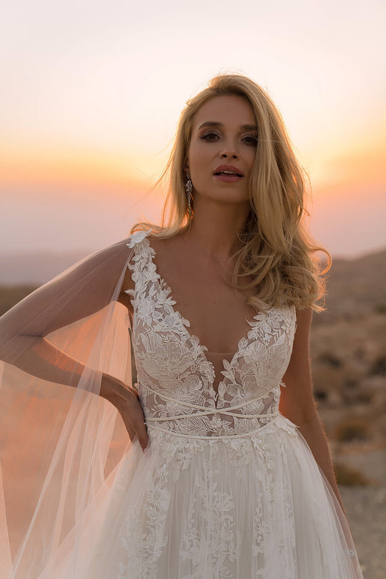 Brautkleid Linda mit tiefem V-Ausschnitt und Blütenspitze, Tüllcape an der Schulter befestigt
