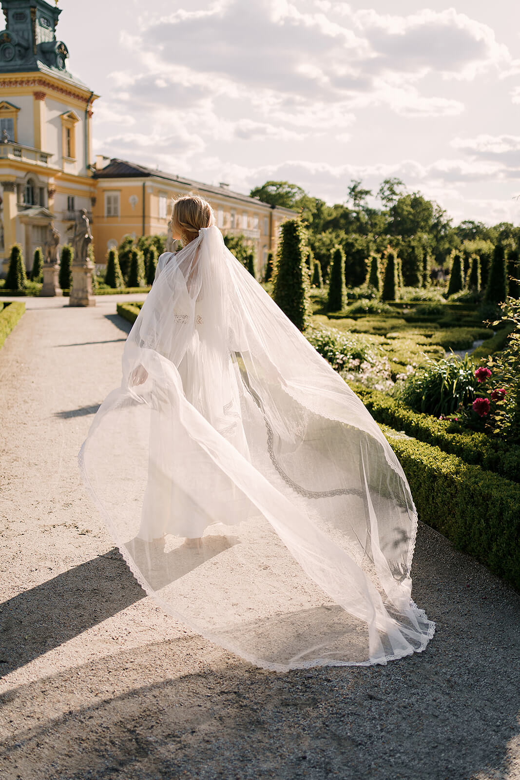 Brautkleid Safona von hinten mit wehendem Schleier auf dem Weg zum Palast