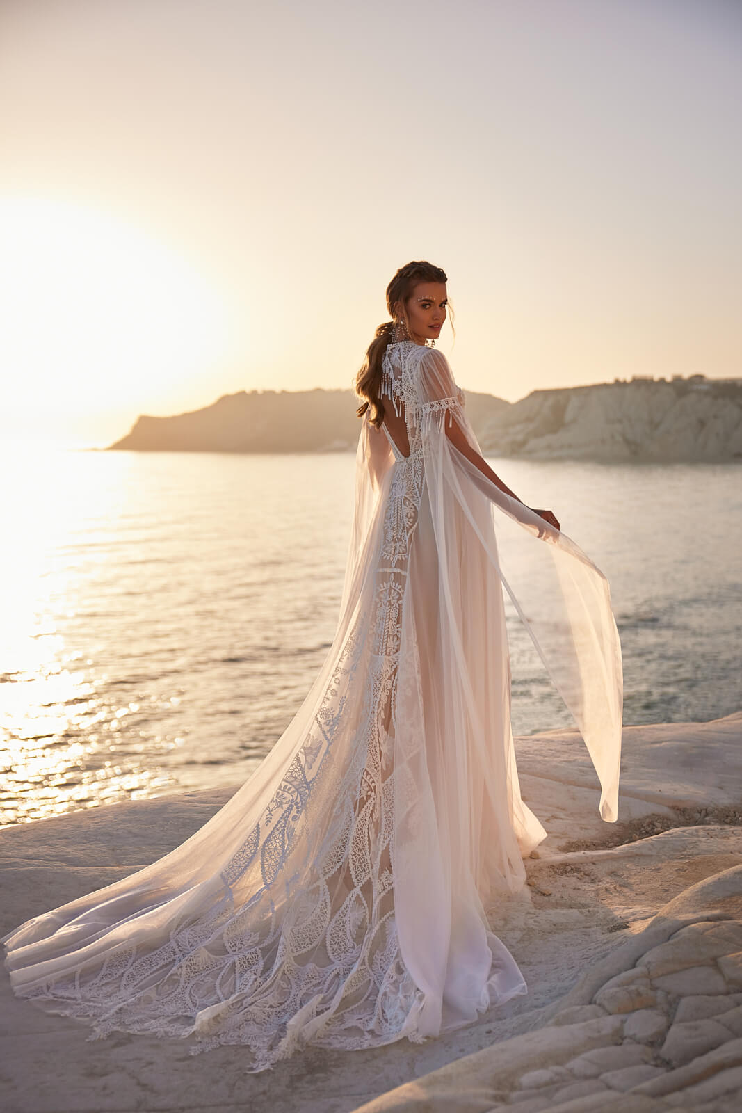 Brautkleid Anvar von hinten mit langer Spitzenschleppe und Tüllärmeln am Meer