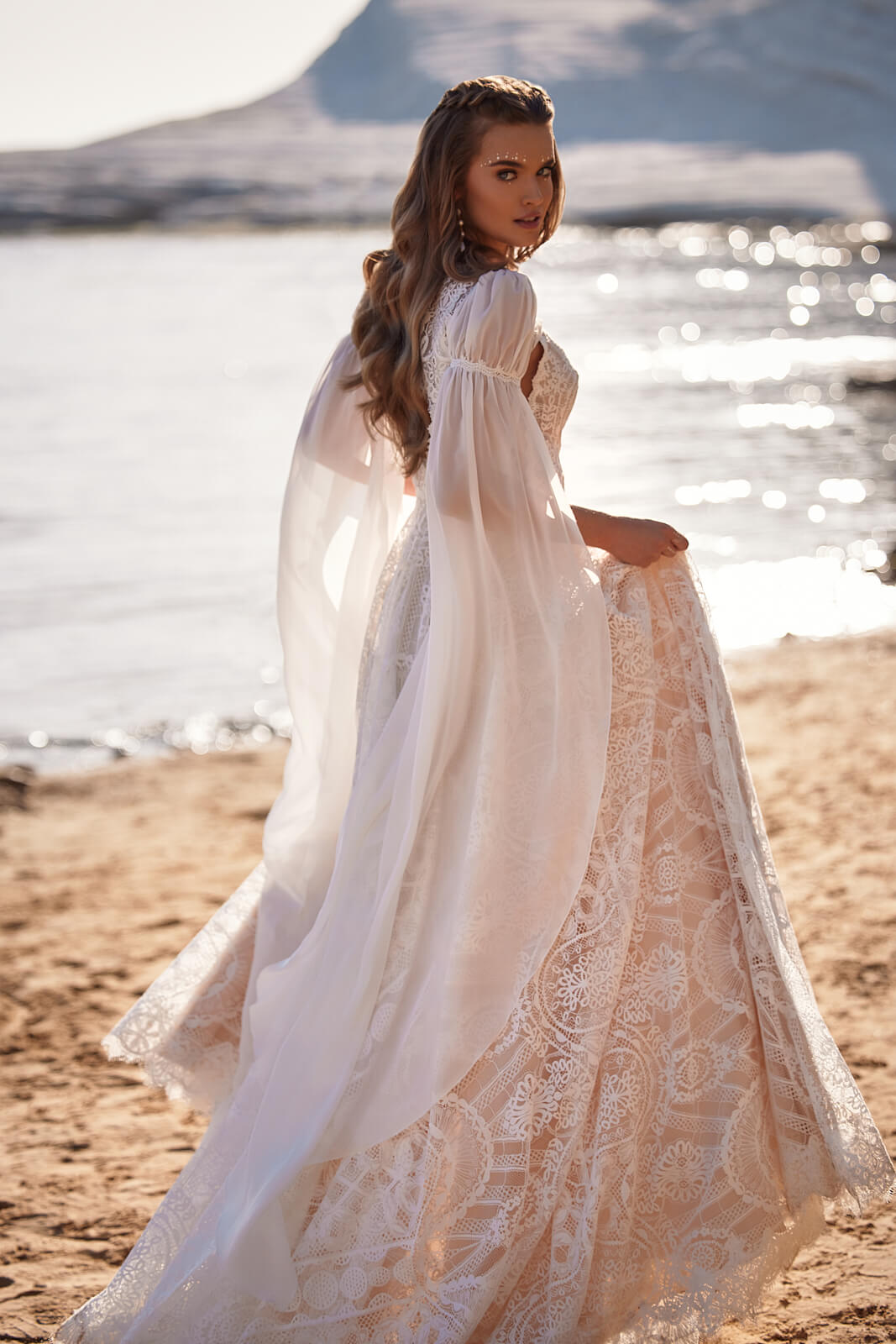 Brautkleid Hope am Strand von hinten, Spitzenrock in A-Linie in der Hand gerafft