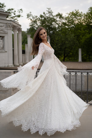 Brautkleid Lea von vorn, ausgebreitete Trompetenärmel und Spitzenrock mit Bogenkante, ganze Figur