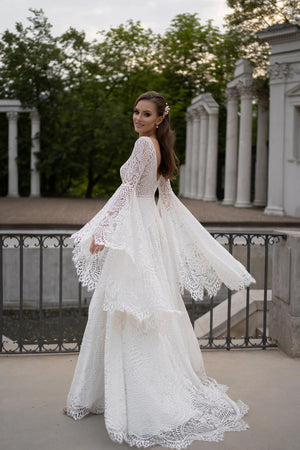 Brautkleid Lea in Bewegung, wehende Trompetenärmel und Spitzenrock, ganze Silhouette von hinten