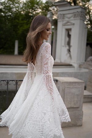Brautkleid Lea von der Seite, Spitzenmuster am Oberteil und weiter Ärmel, Halbfigur im Park