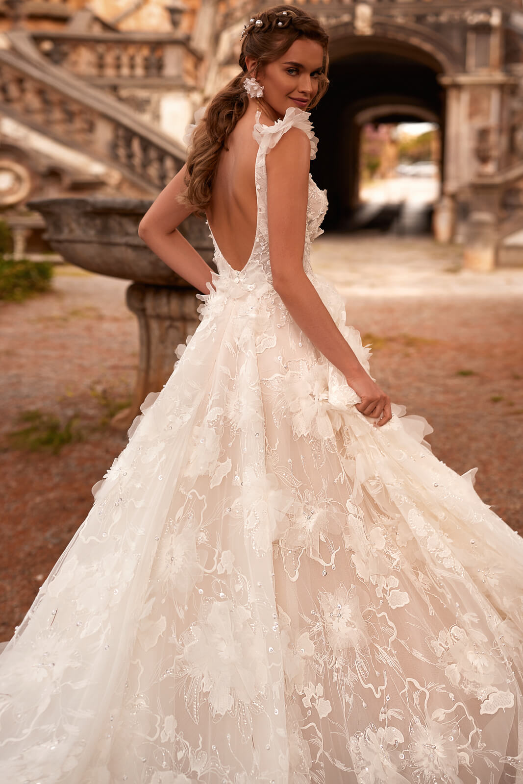 Brautkleid Calanthe mit tiefem Rückenausschnitt, Braut blickt über die Schulter