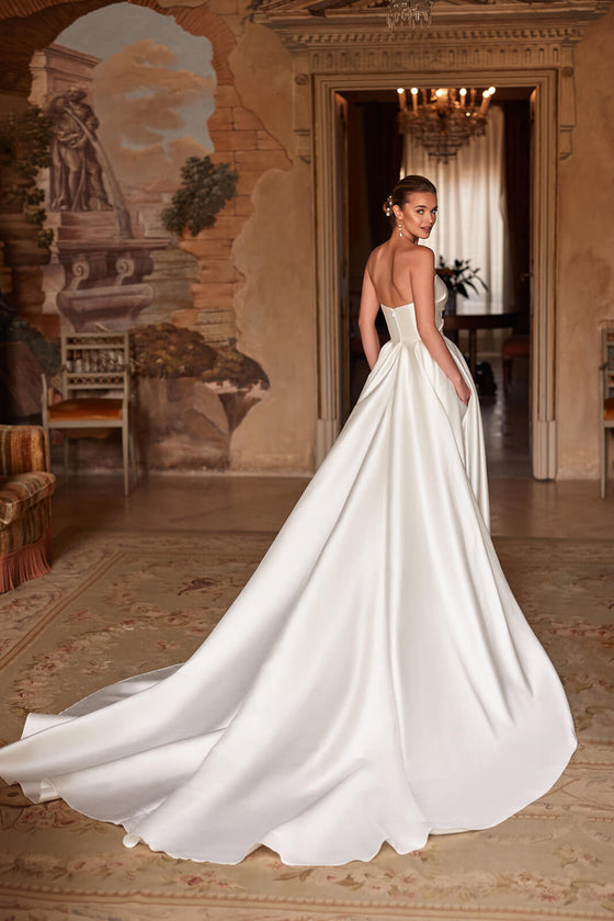Brautkleid Madelaine von hinten, trägerloser Rückenausschnitt und weit ausgebreitete Satin-Schleppe