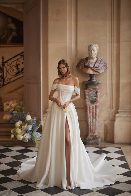 Alienor wedding dress – draped off-the-shoulder sleeves and a clean satin skirt, DAMA Couture Something Blue 2027.