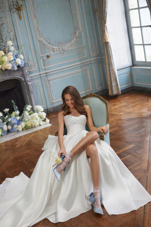 Brautkleid Alizee im Sitzen, der weite Satinrock in A-Linie breitet sich auf dem Boden aus
