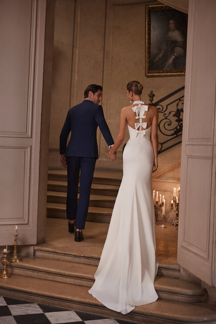 Camilla wedding dress – a pearl-embellished halter collar, wrap draping and thigh-high slit.