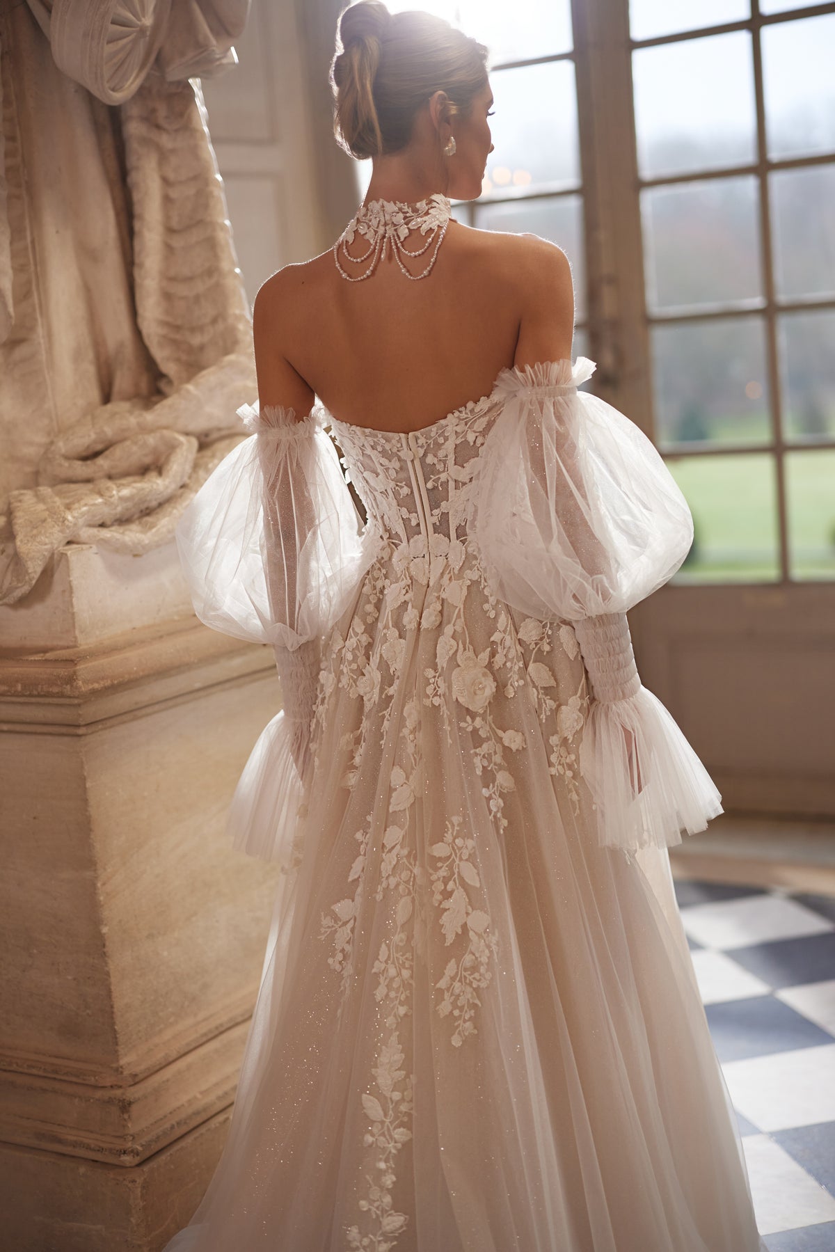 Brautkleid Estella von hinten, offener Rücken mit Knopfleiste und Perlenketten am Choker