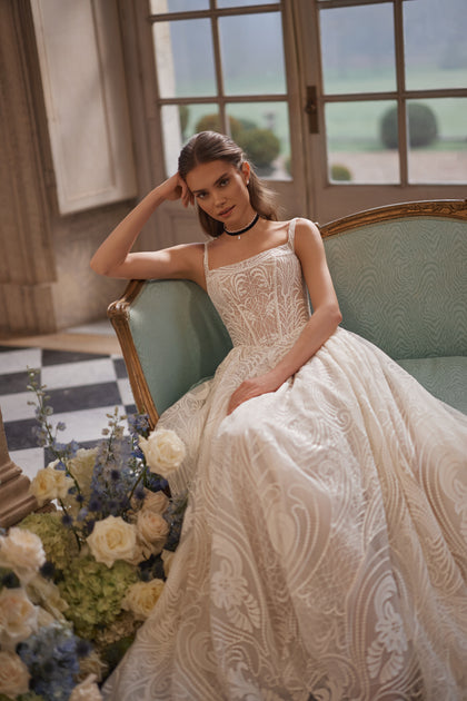 Frigga wedding dress – A-line bridal gown with slender straps, a squared neckline and graphic lace ball skirt.