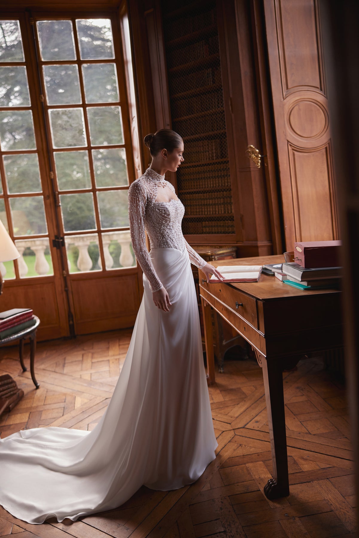 Brautkleid Greta mit Bolero im Profil – langärmelige Perlenstickerei und Satinschleppe