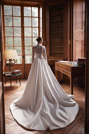 Brautkleid Maristella von hinten am Fenster, Satinrock mit weit gelegter Schleppe