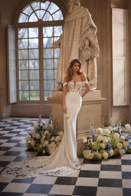 Matilde wedding dress – mermaid bridal gown with an off-the-shoulder neckline and lace-traced fitted silhouette.