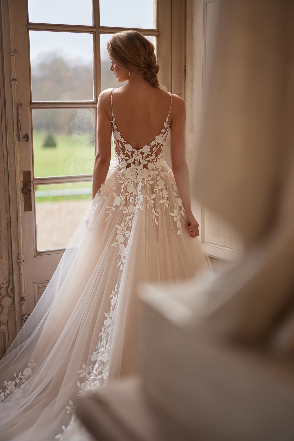 Brautkleid Solene am Fenster, Detailaufnahme des offenen Rückens mit Blumenapplikationen