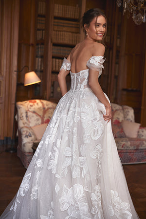 Brautkleid Vespera von der Seite, offener Rücken und Blütenapplikationen auf dem Tüllrock, Halbfigur