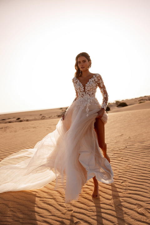 Das Farida-Brautkleid kombiniert ein transparentes Spitzenoberteil mit einem fließenden Tüllrock für eine traumhafte Silhouette.