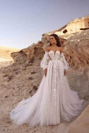 Das Brautkleid Huda mit schulterfreiem Korsett und 3D-Blumenapplikationen verkörpert luxuriöse Boho-Eleganz.