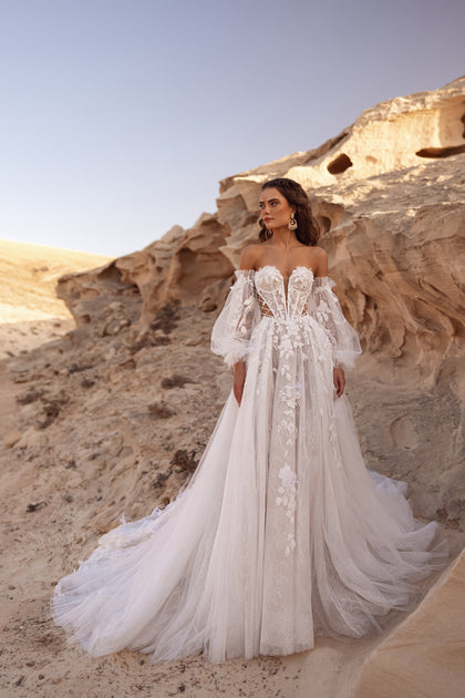 Das Brautkleid Huda mit schulterfreiem Korsett und 3D-Blumenapplikationen verkörpert luxuriöse Boho-Eleganz.