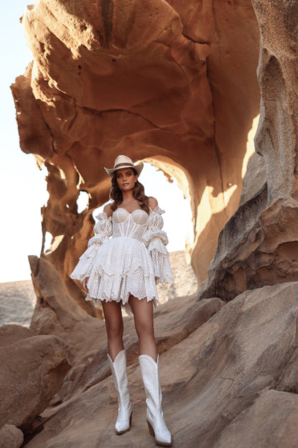 Das Brautkleid Jolena mit Puffärmeln und Stufenrock aus Lochstickerei verkörpert rustikale Boho-Romantik.