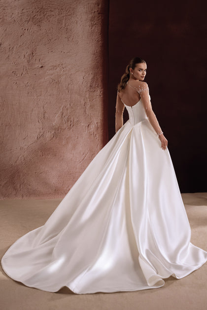 Das Brautkleid Aylin aus Satin mit eleganter Knopfleiste am Rücken betont die feminine Silhouette.