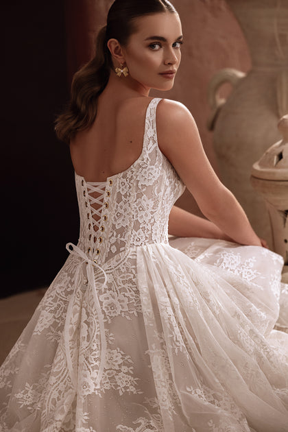 Das Brautkleid Becco mit Schnürung am Rücken und floraler Spitze vereint zeitlose Eleganz mit romantischem Charme.