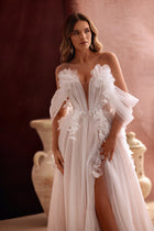 Das Brautkleid Bella mit schulterfreiem Korsett und zarten Tüllblüten strahlt romantische, märchenhafte Eleganz aus.